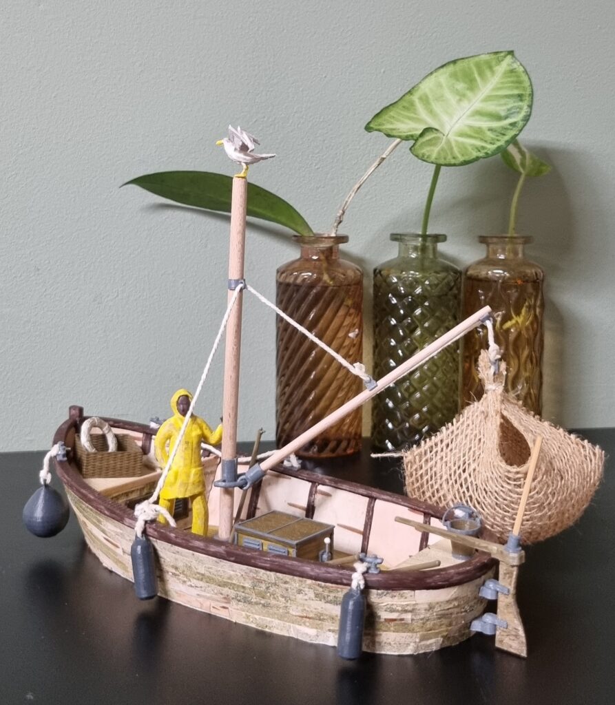 Vissersboot bouwpakket van 3D-geprinte onderdelen en natuurlijke materialen zoals berkenbast.