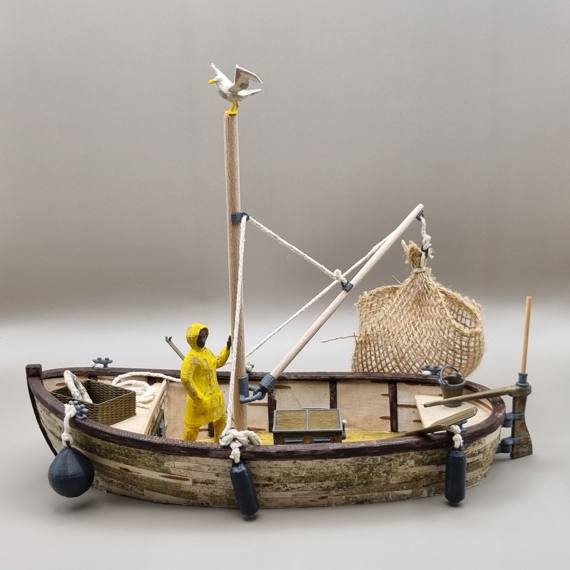 Gedetailleerd 3D-geprint vissersboot bouwpakket afgewerkt met echte berkenbast en houten masten.